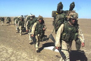 A U.S. Marine with the 15th Marine Expeditionary Unit leads others to a security position after seizing a Taliban forward-operating base 25 November 2001
