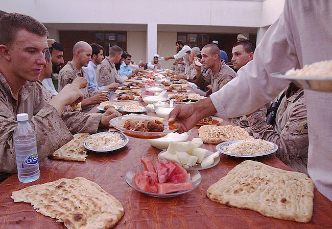 Marines from 1st Battalion, 3rd Marine Regiment and district government officials enjoy Iftar or ‘breaking of fast,’ which is the nightly meal during the month-long Islamic holiday Ramadan, Aug. 8. Marines from 1/3 are regularly invited to Iftar with their Afghan National Army and Police counterparts during Ramadan. (Photo by Cpl. Colby W. Brown: Courtesy of WikiCommons)
