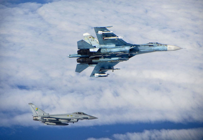 Royal Air Force Eurofighter Typhoon (bottom) escorts Russian Air Force Su-27 Flanker (top) over the Baltic in June 2014. (Photo: Courtesy of RAF/WikiCommons)